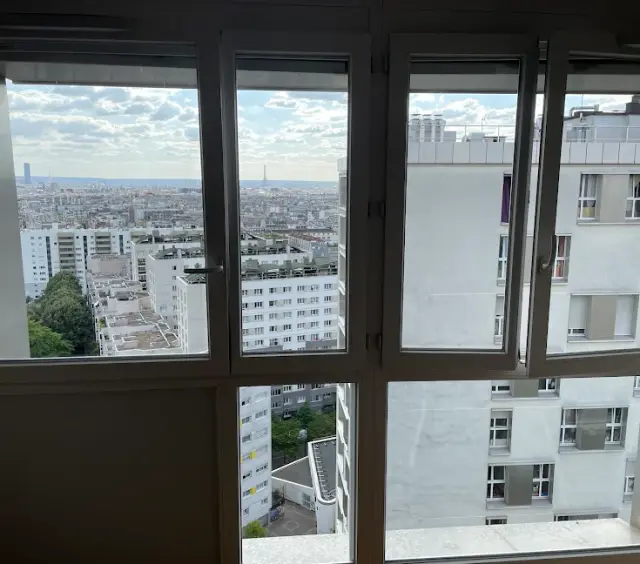 Fenêtres d'un appartement en étage élevé parfaitement nettes, avec vue dégagée sur Paris et la tour Eiffel